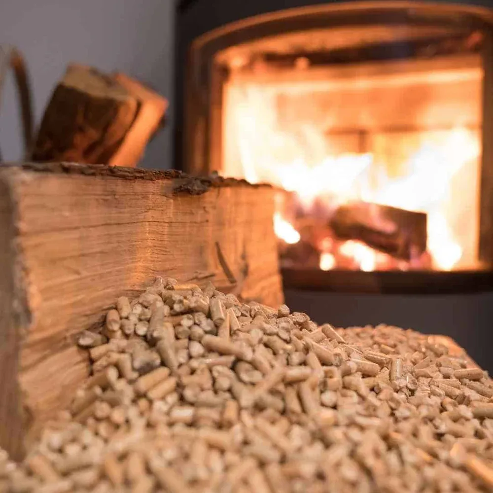Granulés de bois en gros plan devant la flamme d’un poêle